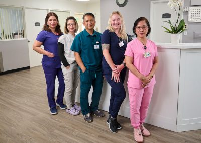 A group of caregivers at the nurse's station in the Valle Vista facility hallway