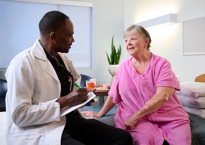 An African American caregiver with a resident in the Valle Vista facility