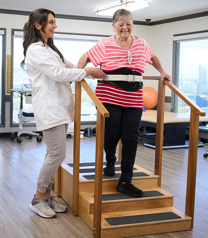 A therapist with a resident in the rehab gym