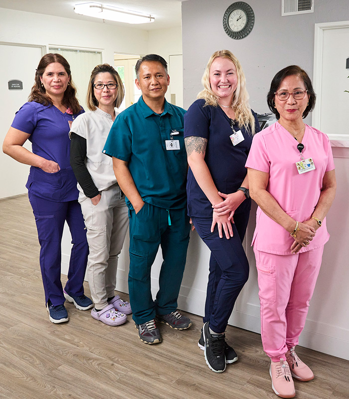 A group of caregivers at the nurse's station in the Valle Vista facility hallway